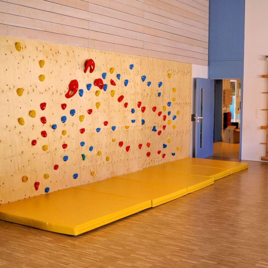 Fallschutzmatten vor einer Kletterwand in der Kita