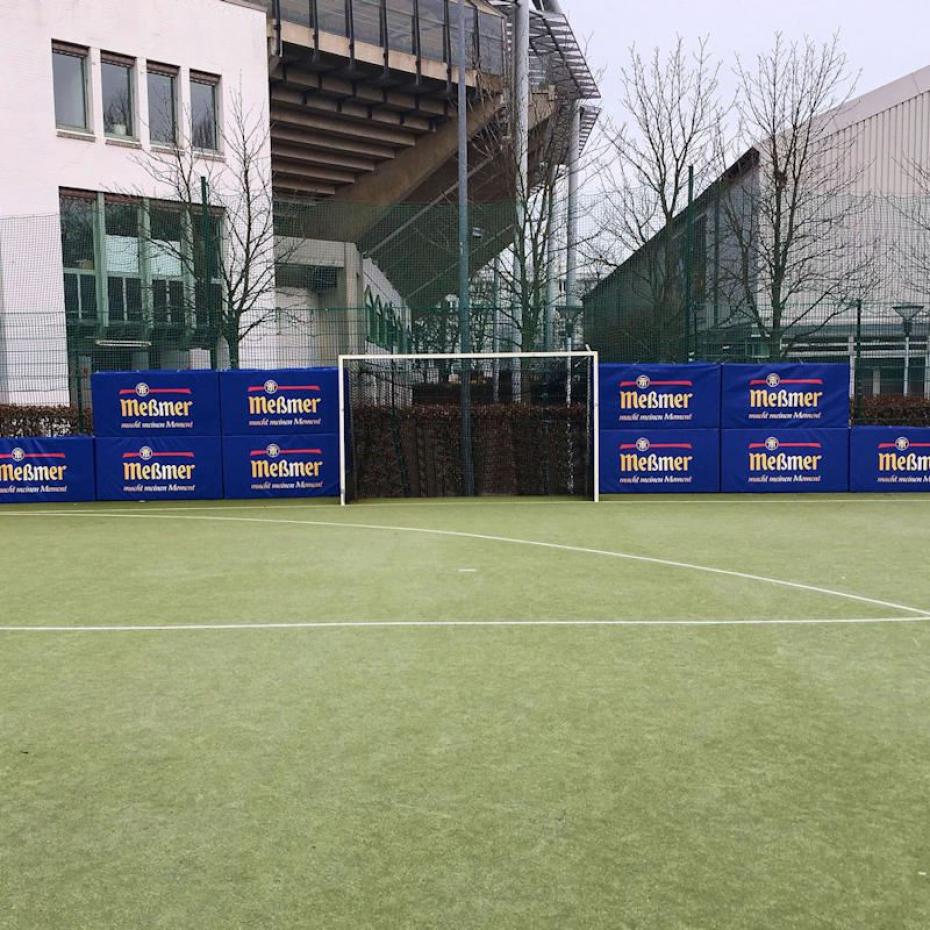 Prallschutzmatten auf Sportplatz mit Sponsoren-Logo